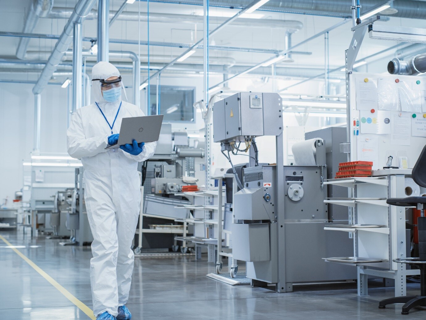 A scientist using laptop in a manufacturing facility